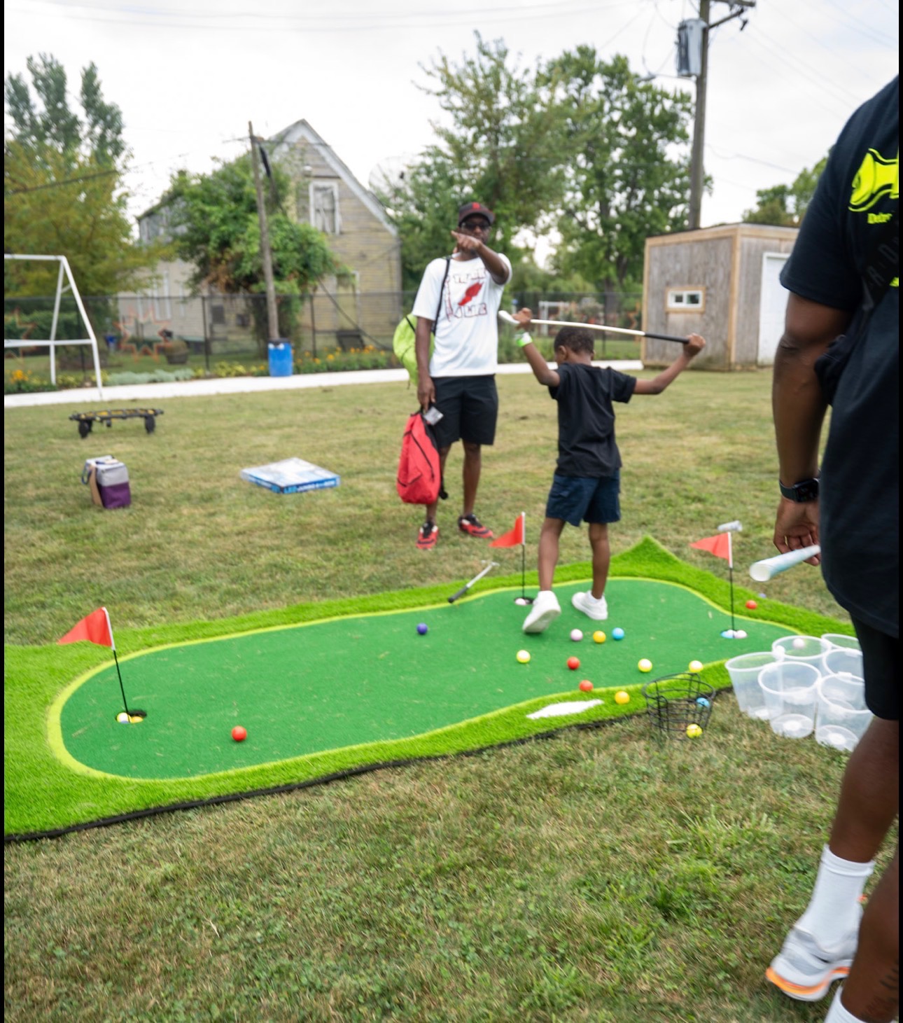 Youth playing mini golf at community event