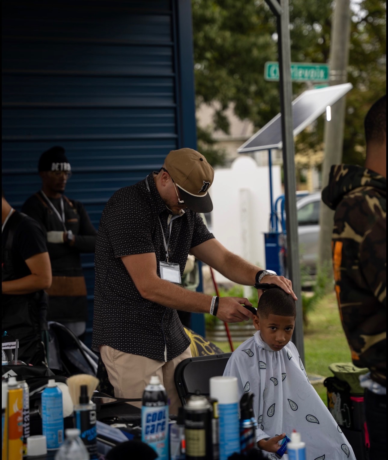 Volunteer barber serving young community member